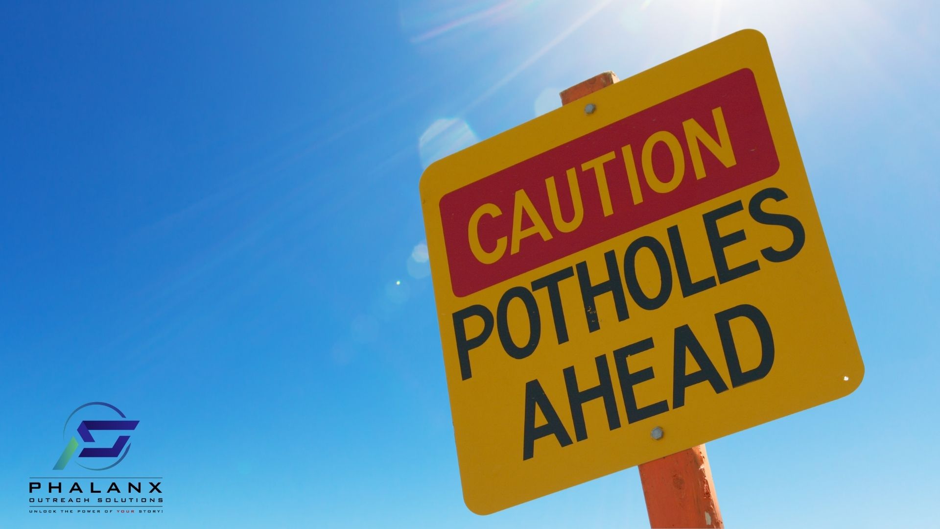 Sign that reads Caution Potholes Ahead